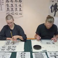 Deux personnes qui font la calligraphie